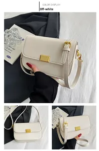 Detail view of off-white leather shoulder bag with gold metal clasp and square design