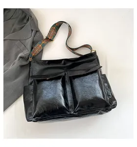 Detail of black wax faux leather tote with vintage ethnic print wide shoulder strap