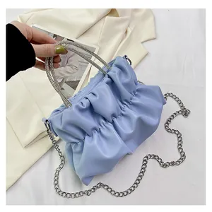 Détails d'un sac nuage plissé bleu clair avec poignées en strass et chaîne argentée