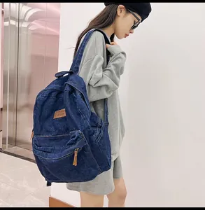 Seitenansicht des dunkelblauen Denim-Rucksacks mit Lederpatch an einem Model