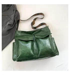 Detail of dark green vintage tote bag with retro geometric strap and bronze hardware