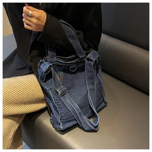 Detailed view of dark blue denim tote bag with jean-style waist buckle and strap details