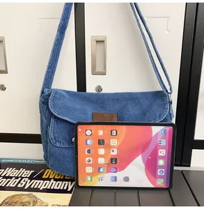 Detail of blue denim messenger bag showing large capacity for a tablet and retro style