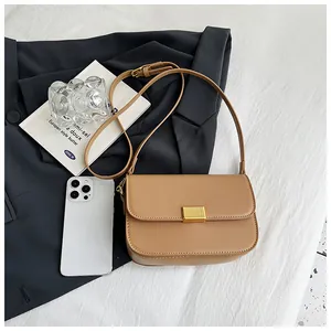 Detailed view of camel leather textured crossbody bag with golden metal stripe closure