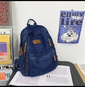 Detailed macro view of high-quality navy denim texture and brown leather logo on a backpack