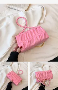 Detailansicht der rosa Faltenhandtasche mit Goldkette und weicher Lederstruktur