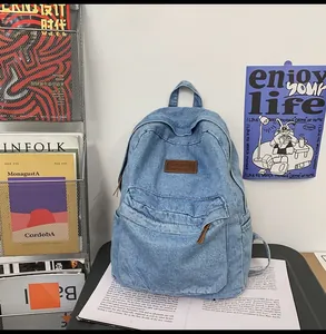 Detailansicht der blauen Denim-Textur und des braunen Leder-Patches am Rucksack