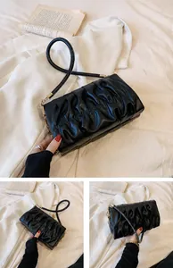 Detailansicht der schwarzen Falten-Tasche mit feiner Textur und goldener Schnalle