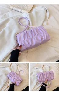 Detail der lila gefalteten Wolkentasche aus glänzendem PU-Leder mit goldener Kette
