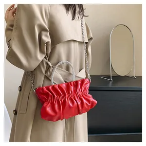 Detail of red pleated cloud bag with rhinestone handle and silver chain strap