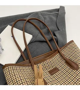 Detail of checkered tote bag with brown PU leather trim and a cute bunny pendant