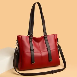 Sac à main élégant en cuir rouge avec bandoulière amovible et anses marron foncé