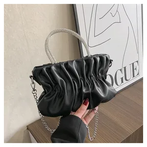 Detail of black pleated cloud bag featuring a sparkling rhinestone handle and silver chain