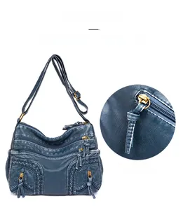 Detail view of the durable zippers and woven texture on a blue washed leather handbag