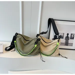 Detail of army green and beige oversized tote bags with neon woven chain accents