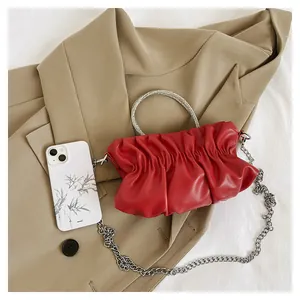 Detail of red pleated cloud bag with rhinestone ring handle and silver chain strap