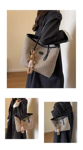 Detail of checkered tote bag featuring a plush rabbit pendant and wide shoulder straps
