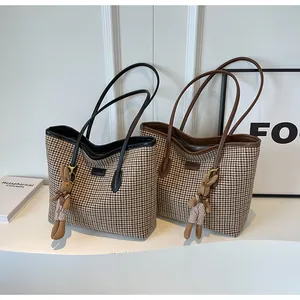 Close-up of houndstooth tote bags with plush bunny charms and premium textured fabric
