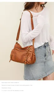 Detail view of brown PU leather crossbody bag featuring woven texture and zipper pockets