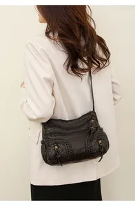 Side view of multi-pocket brown washed PU leather crossbody bag worn by model
