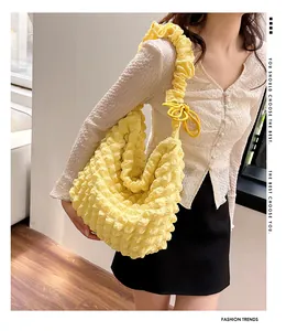 Detail of yellow popcorn textured tote bag showing 3D pleated fabric and shoulder strap