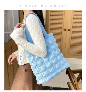 Detail of light blue quilted bubble fabric tote bag with soft puffy diamond pattern