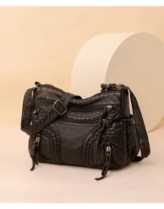 Close-up of black washed PU leather handbag with multi-layer zippers and bronze hardware