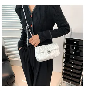 Détail du petit sac blanc matelassé avec fermoir métallique et bandoulière chaîne