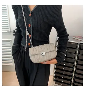 Détail du sac à bandoulière matelassé gris clair avec surpiqûres en V et chaîne argentée