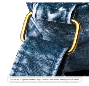 Detailed macro view of the rectangular gold metal ring on a navy faux leather shoulder bag