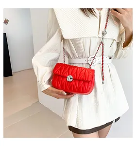 Détails du sac bandoulière rouge matelassé avec chaîne argentée et breloque sphérique