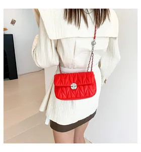 Détail du sac bandoulière rouge matelassé en V avec chaîne argentée et fermoir