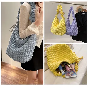 Detail of bubbly textured tote bag showing spacious interior for iPad and cosmetics