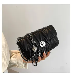 Détail du cuir matelassé en V noir avec chaîne argentée et boule métallique ajustable