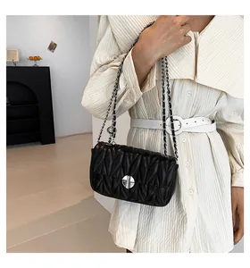 Détail du sac bandoulière matelassé noir avec chaîne argentée et fermoir pivotant