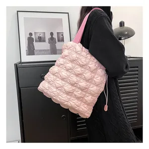 Detail of pink quilted bubble tote bag featuring wide strap and side drawstring accent