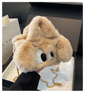 Dettaglio della borsa in peluche beige con grandi occhi e tracolla a catena d'oro