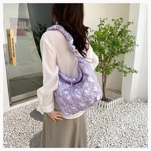 Close-up of light purple quilted puff bag with textured gathered shoulder strap