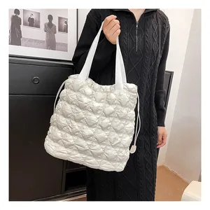White quilted bubble tote bag with ruched texture shown on shoulder for daily commute