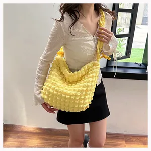 Macro detail of the yellow popcorn textured fabric and pleated design on this crossbody bag