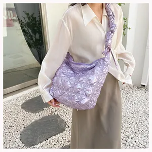 Chic light purple quilted crossbody bag with gathered strap shown on a model