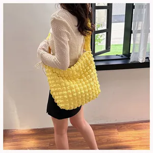 Detailed macro view of yellow bubble textured fabric on a large crossbody hobo bag