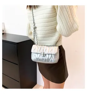 Détail du sac matelassé argenté avec finition métallique et boucle coulissante à bille