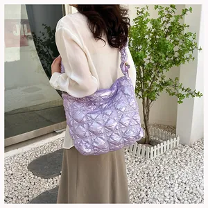 Close-up of a purple quilted puff tote bag with textured ruffles and shoulder strap