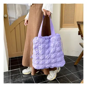 Close-up of purple quilted tote bag with diamond stitching and adjustable drawstring side