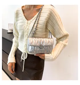 Détail du sac bandoulière argenté matelassé avec bandoulière chaîne et fermoir rotatif