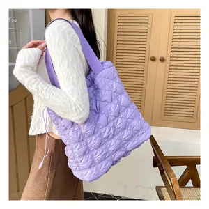 Detailed close-up of purple quilted puffer bag with drawstrings and padded texture