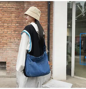 Detail of vintage blue denim crossbody bag with multiple exterior pockets and large capacity