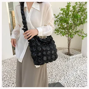 Detailed view of black quilted puff texture on a large capacity cloud shoulder bag