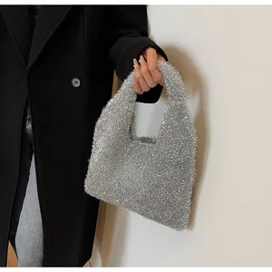 Close-up of shiny silver sequin underarm bag with shimmering fabric texture for women